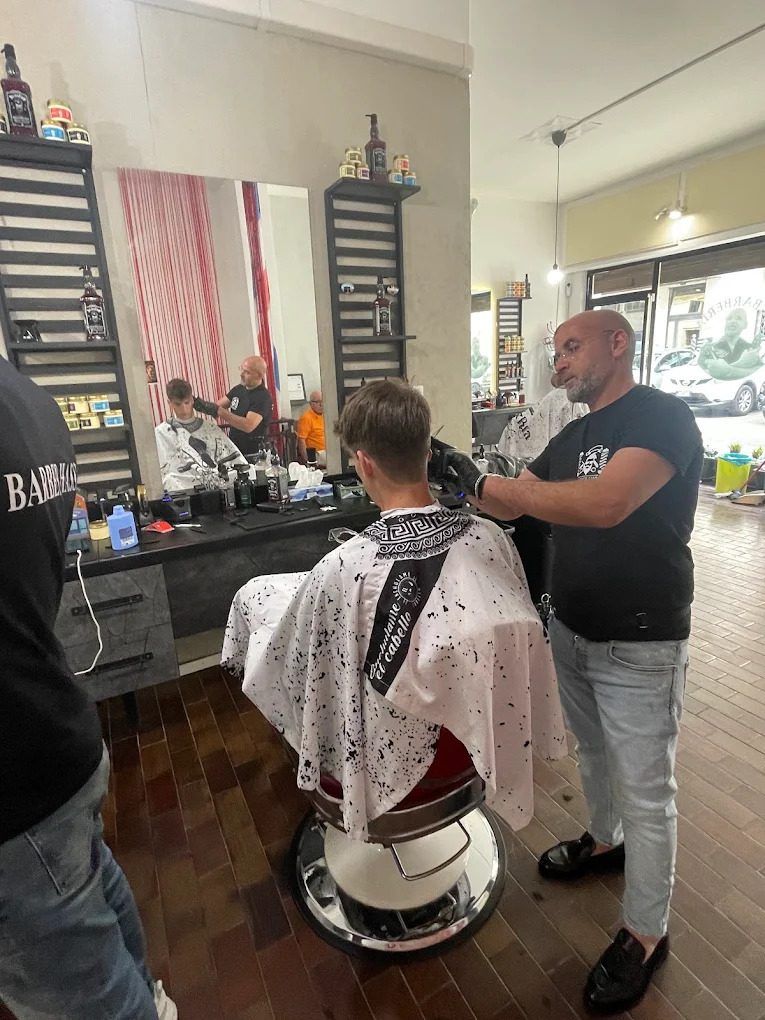 Barbiere al lavoro su un taglio da Hassan Barber Verona